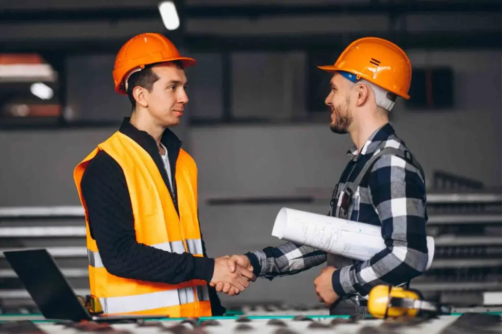 Dos trabajadores se dan la mano