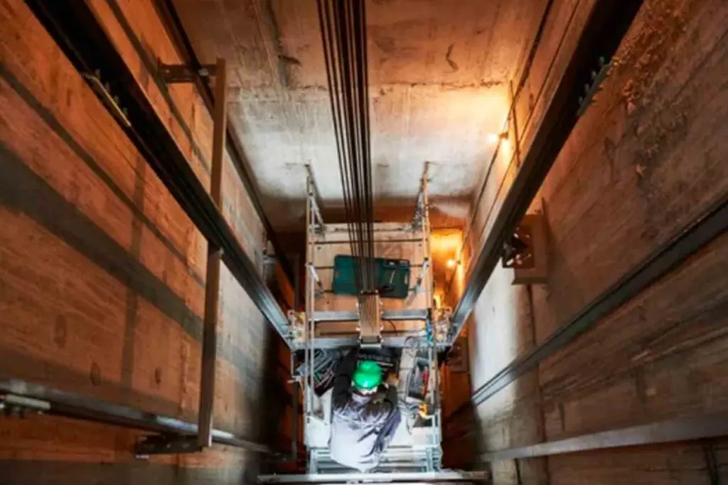 un trabajador encima de un ascensor